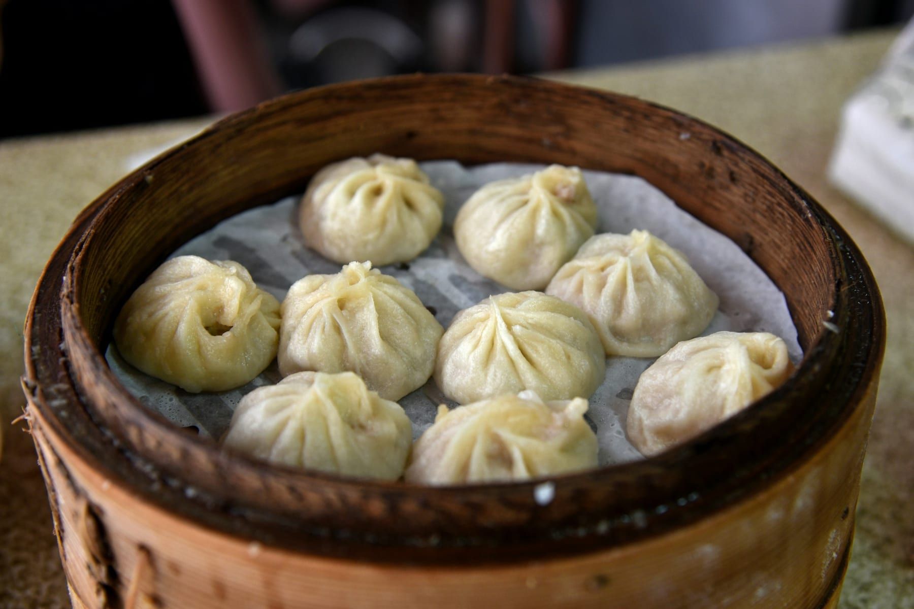 Steamed momos in a bamboo steamer